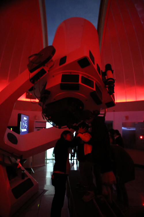  在“月亮与星星公开观测活动”中，国立果川科学馆有关人士帮助孩子用望远镜观测天体。